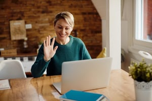 happy-woman-greeting-someone-during-video-call-home